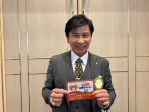 NPO応援サポーターのカードを持つ、さくらいデンタルクリニック理事長の櫻井健次さん